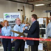 Lima/Allen County Chamber of Commerce President/CEO Jed Metzger instructs Executive Director Lavon Welty on how to use the BIG scissors to avoid smashed fingers.